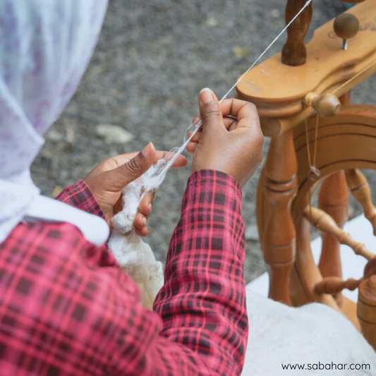 Een jonge vrouw die katoen spint