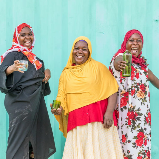 drie vrouwen uit Zanzibar die poseren met hun handgemaakte producten